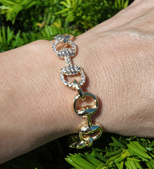 Adelaide gold horsebit bracelet styled on wrist with polished oversized links