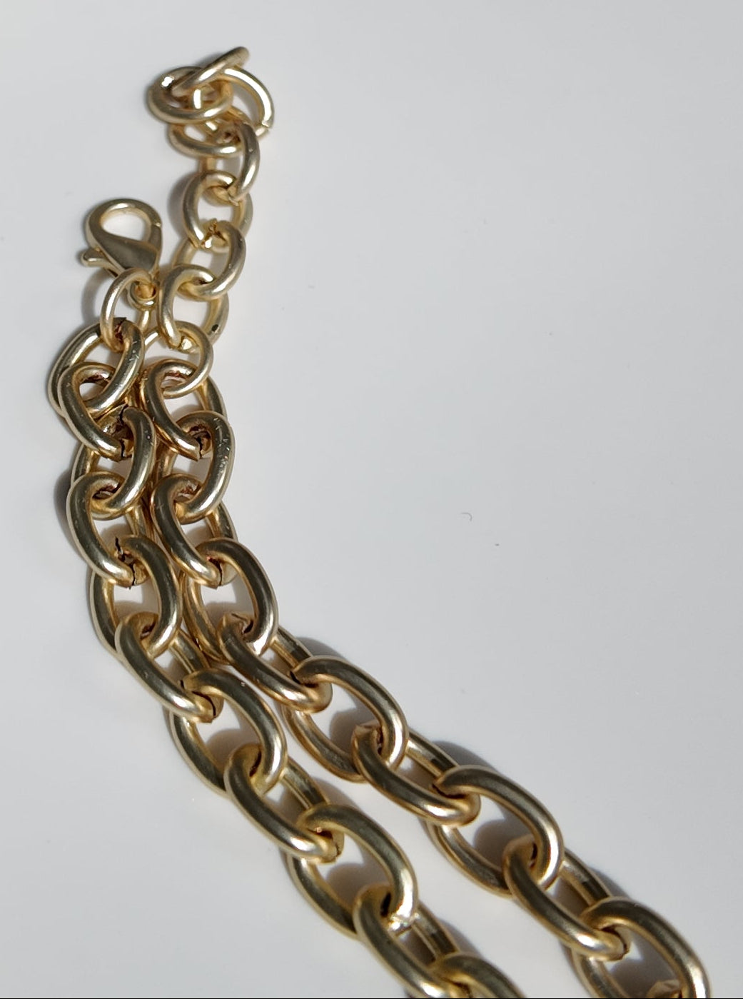 Close-up of matte gold chain detail on the Evangeline Cross Necklace