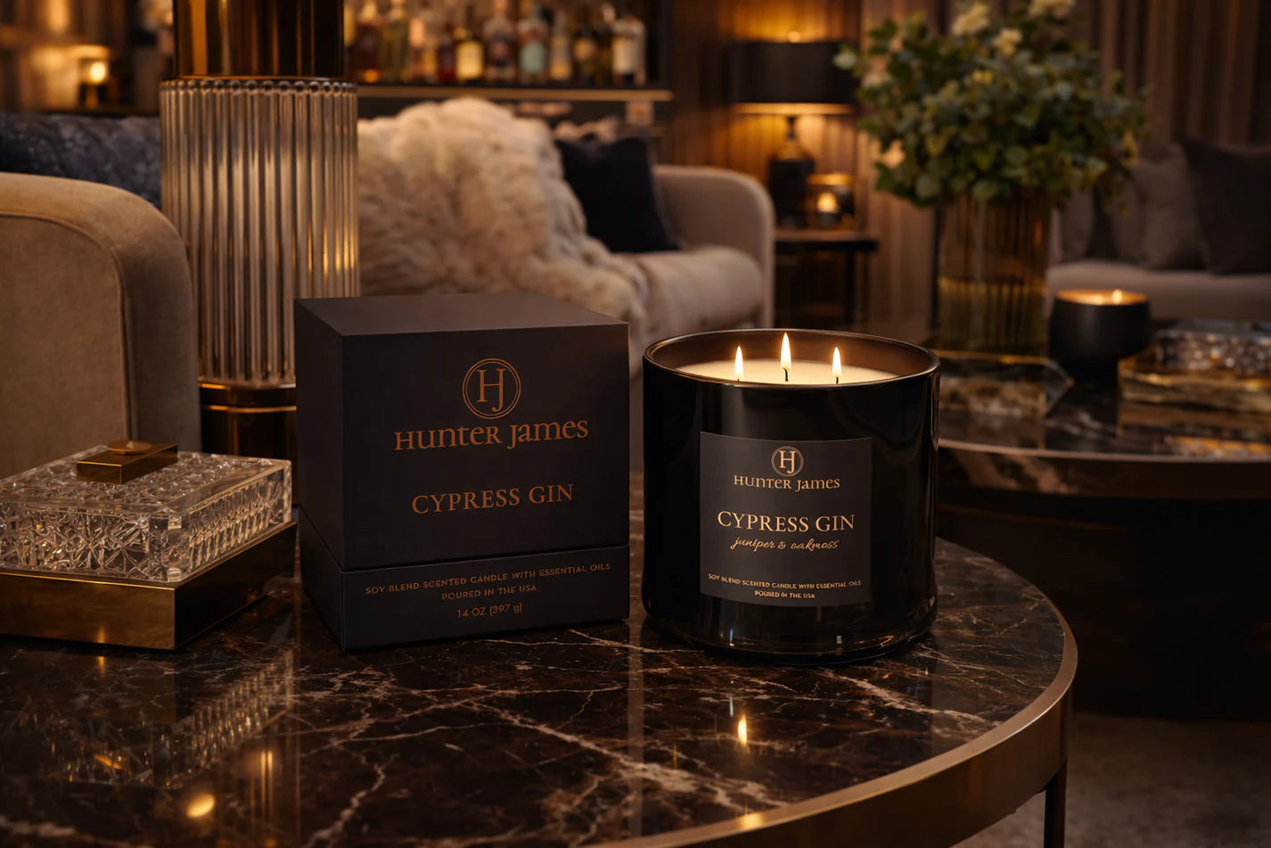 Hunter James Cypress Gin candle and packaging on a marble surface with a cozy interior background.