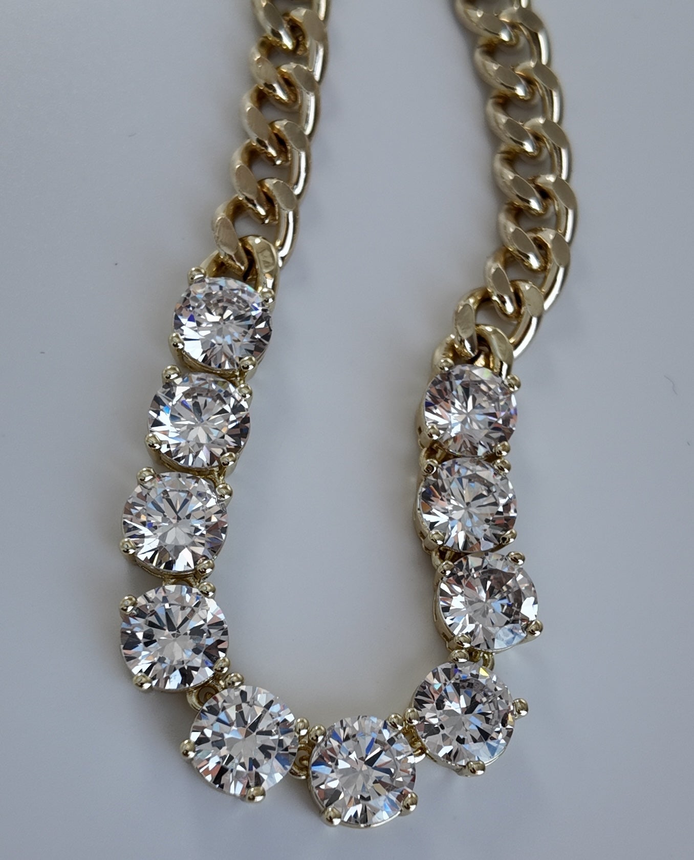 Close-up of gold chain necklace with large brilliant cubic zirconia stones and polished gold links