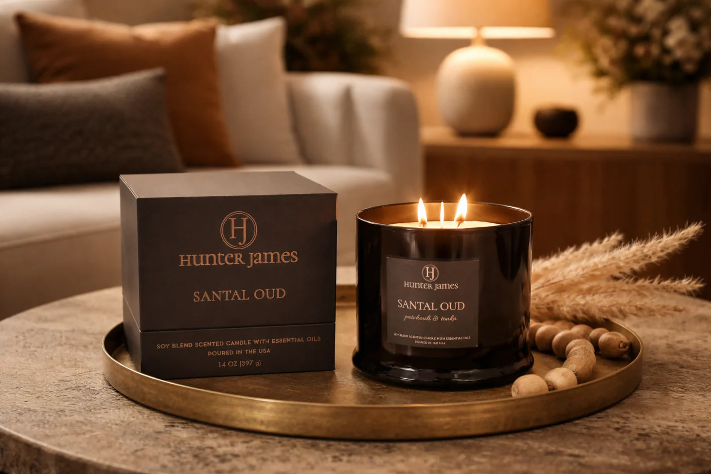 Hunter James Santal Oud candle and packaging on a wooden tray in a cozy living room setting.