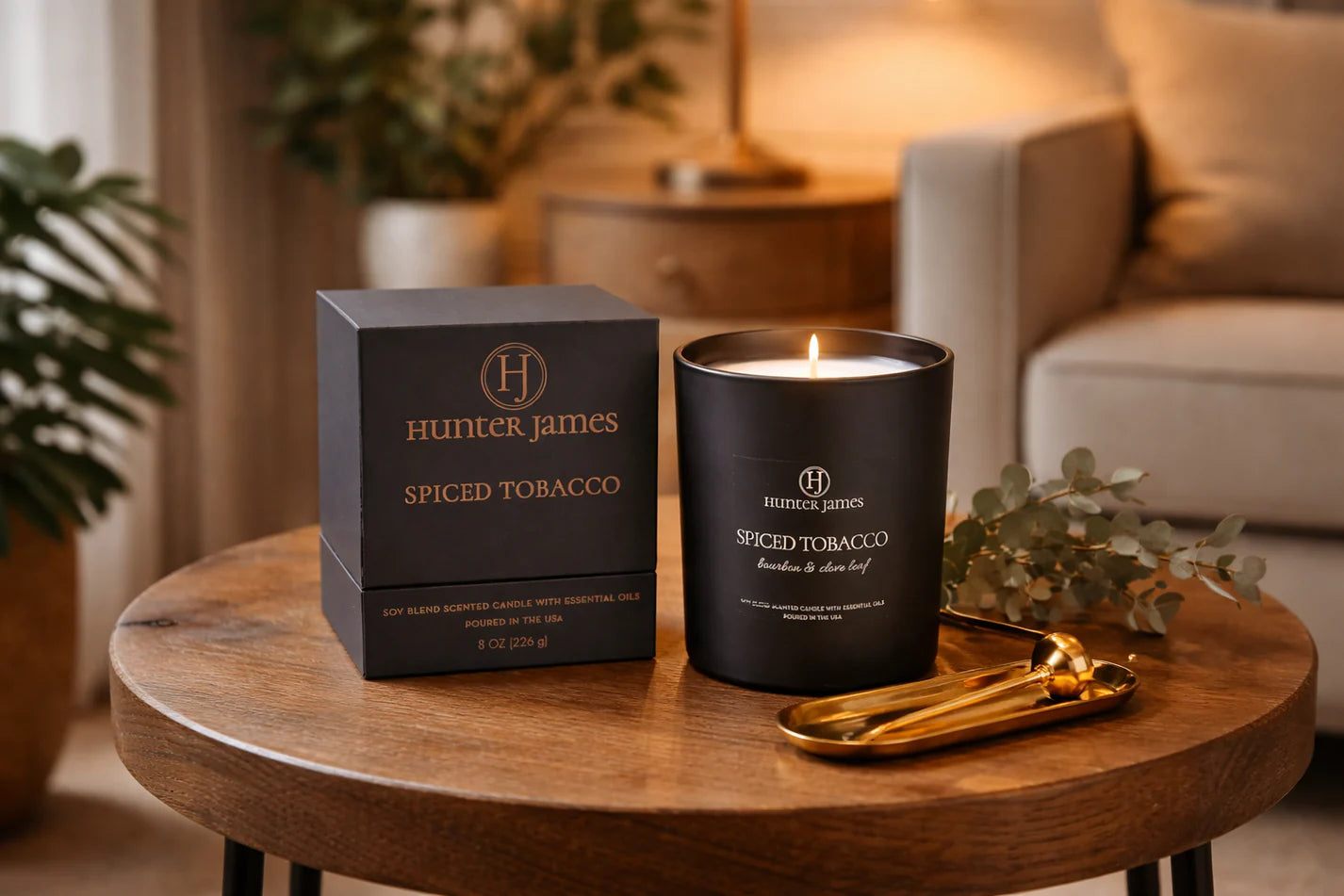 Hunter James spiced tobacco candle and packaging on a wooden table with a cozy indoor setting.