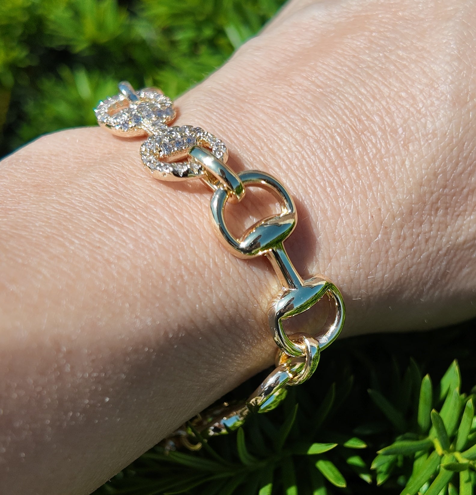     Close-up of Adelaide gold horsebit link bracelet with pavé crystal accents worn on wrist