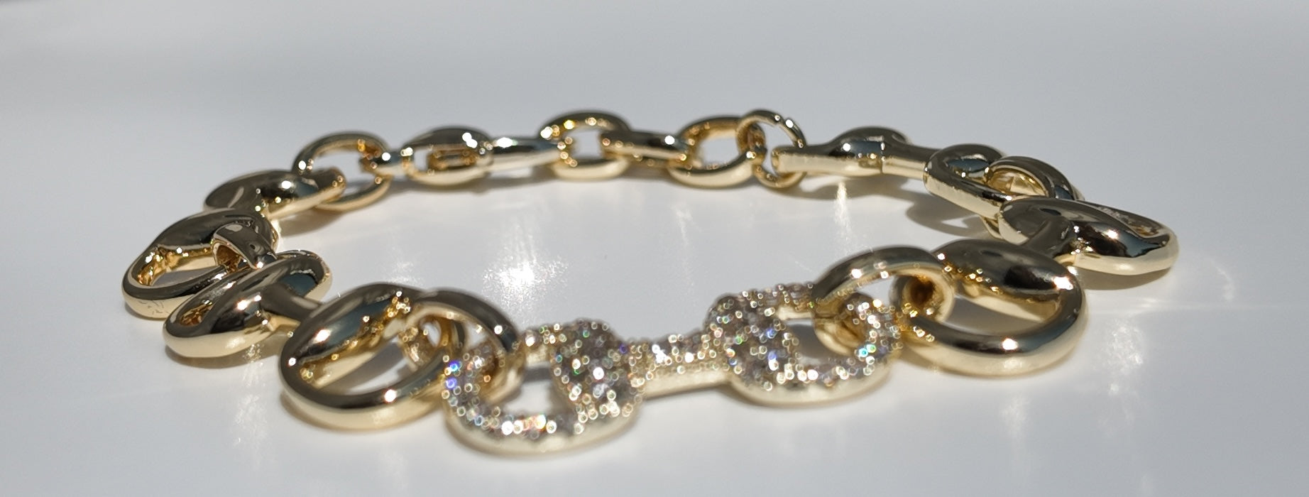     Flat lay of Adelaide gold horsebit link bracelet with pavé detailing