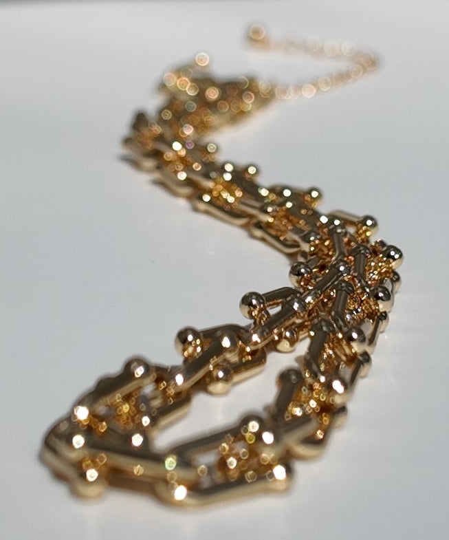 Gold Blaire paperclip chain necklace photographed in a flat lay showcasing polished geometric chain links