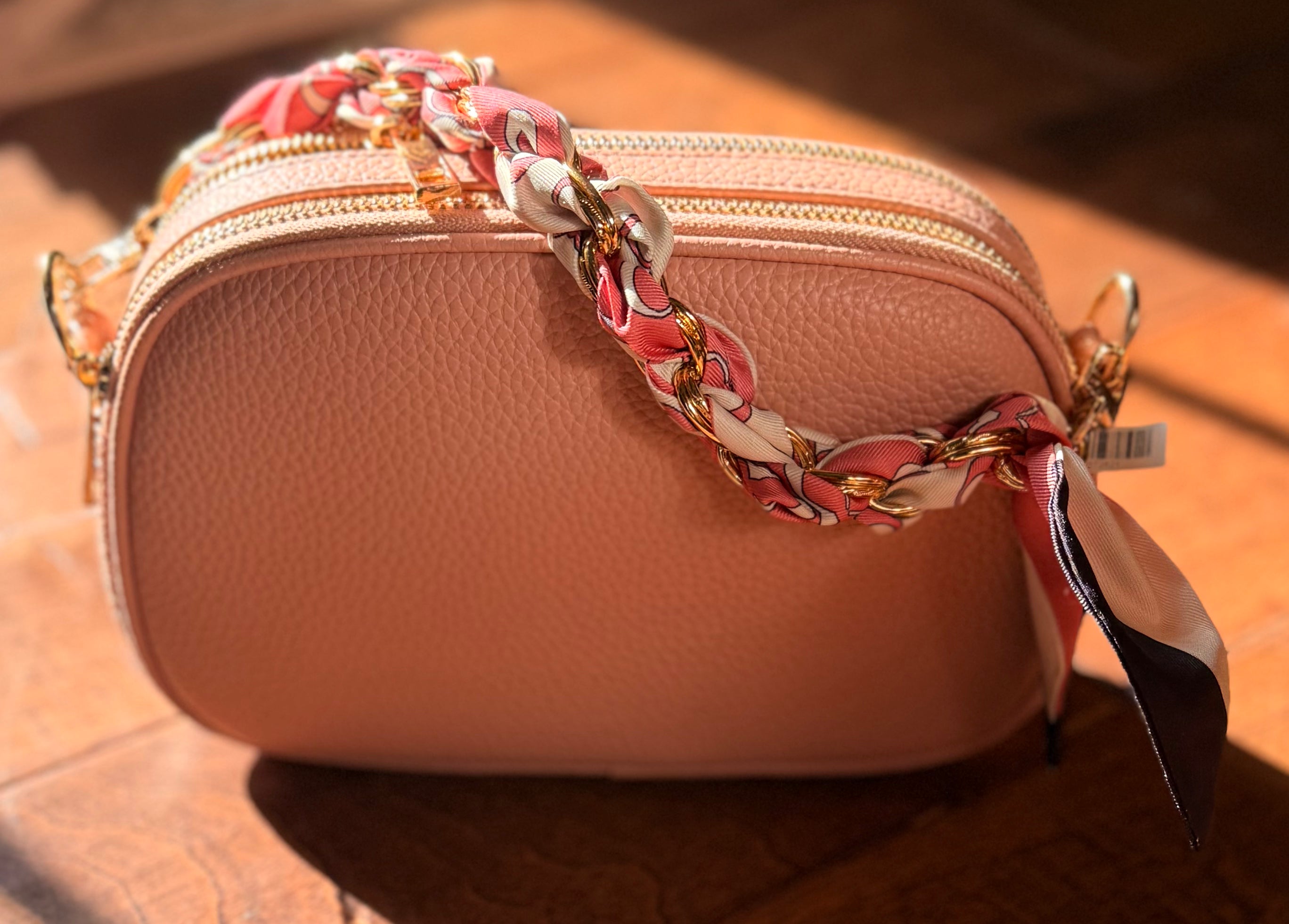 The Elodie Pebble Crossbody in Desert Rose with a decorative scarf accent and gold-tone hardware. Phone Chain 9"