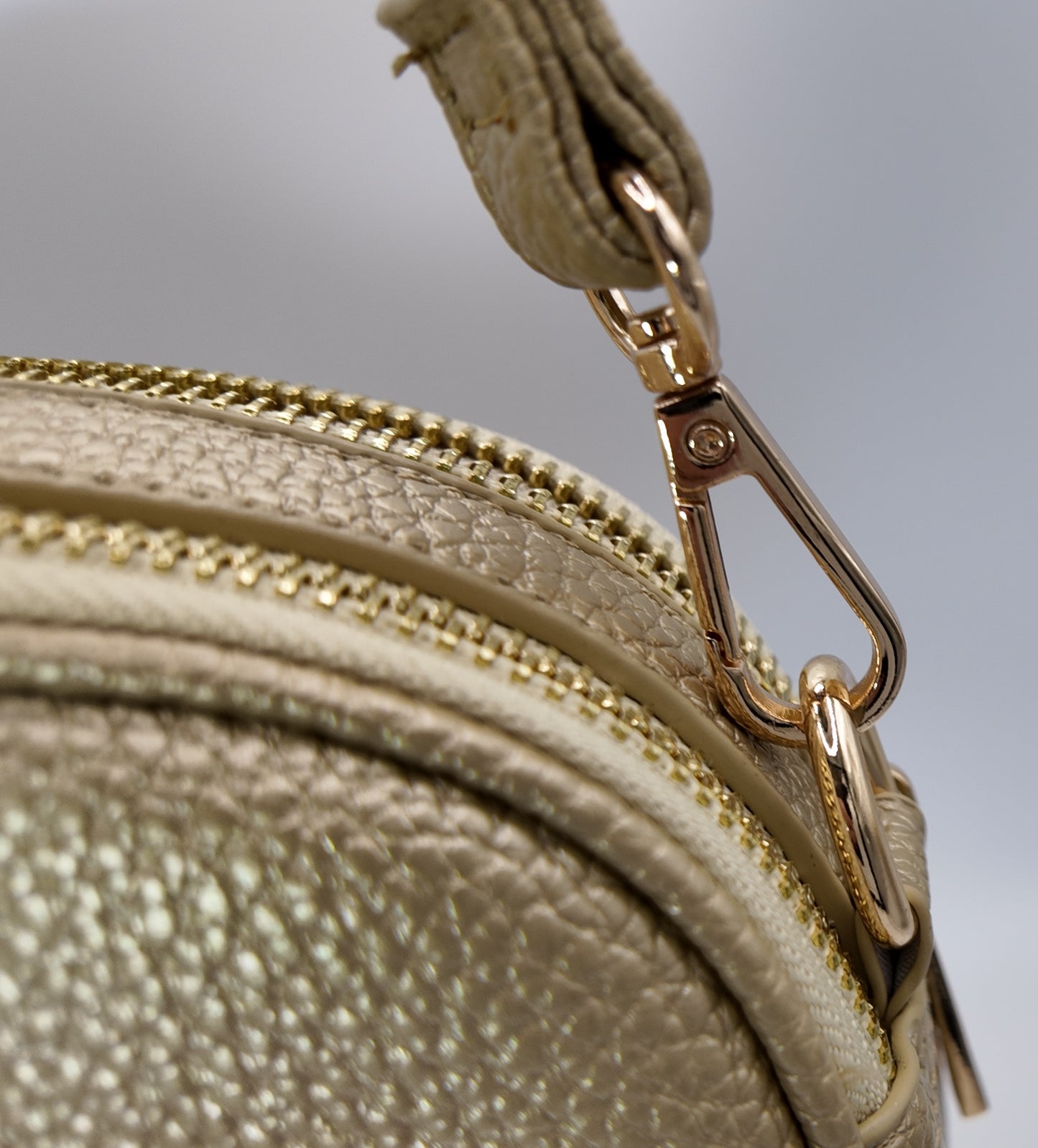 Close-up detail of gold-tone hardware and pebble texture on The Elodie Pebble Crossbody.