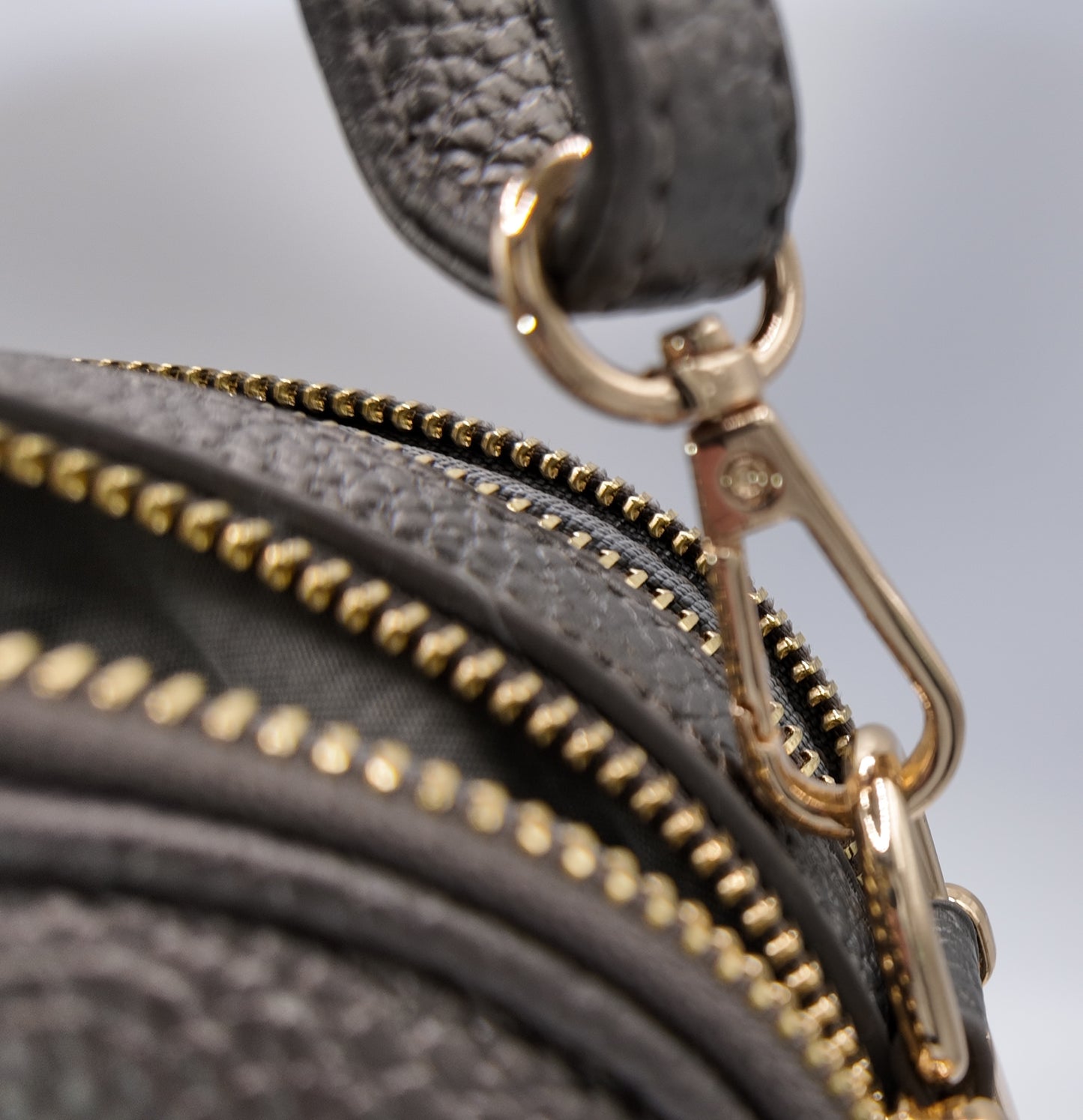 Close-up detail of The Elodie Pebble Crossbody in Midnight Onyx with gold clasp hardware.