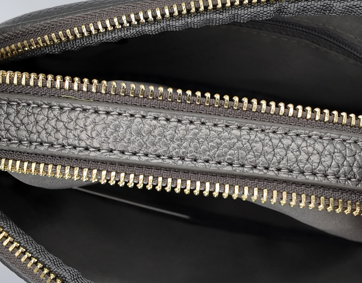 Close-up zipper detail of The Elodie Pebble Crossbody showing gold hardware and structured design.