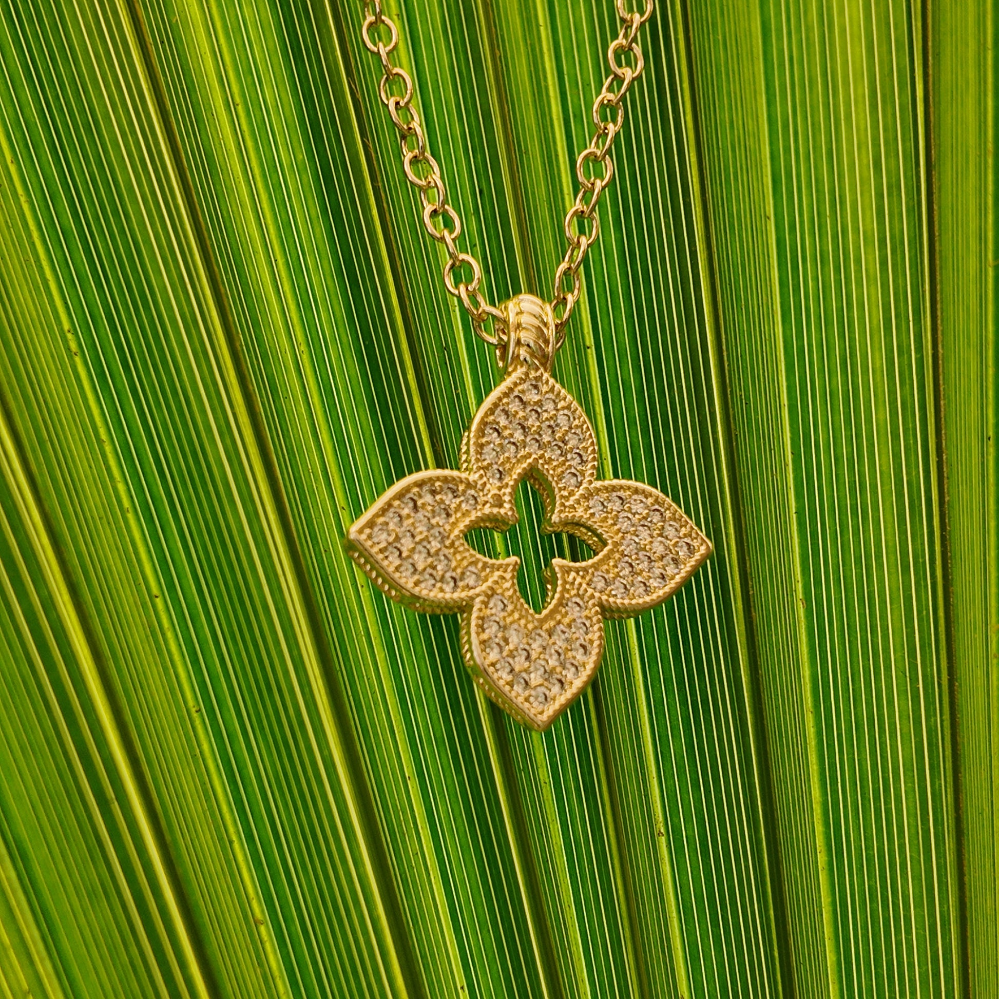 Close-up of Juliette Open Motif Necklace with pavé detailing and gold chain styling