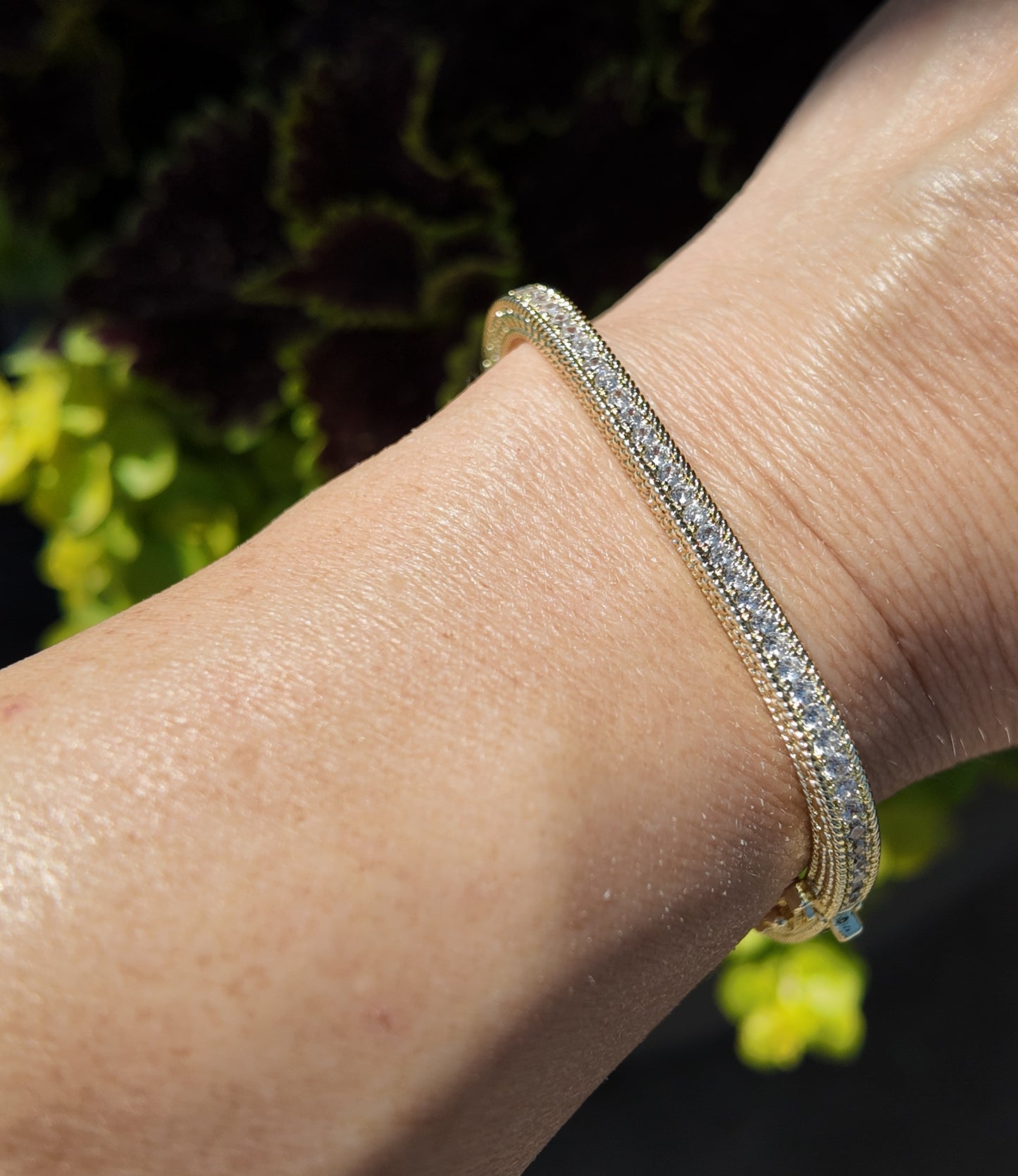     Close-up of Monaco gold tennis bangle bracelet with sparkling cubic zirconia detailing worn on wrist