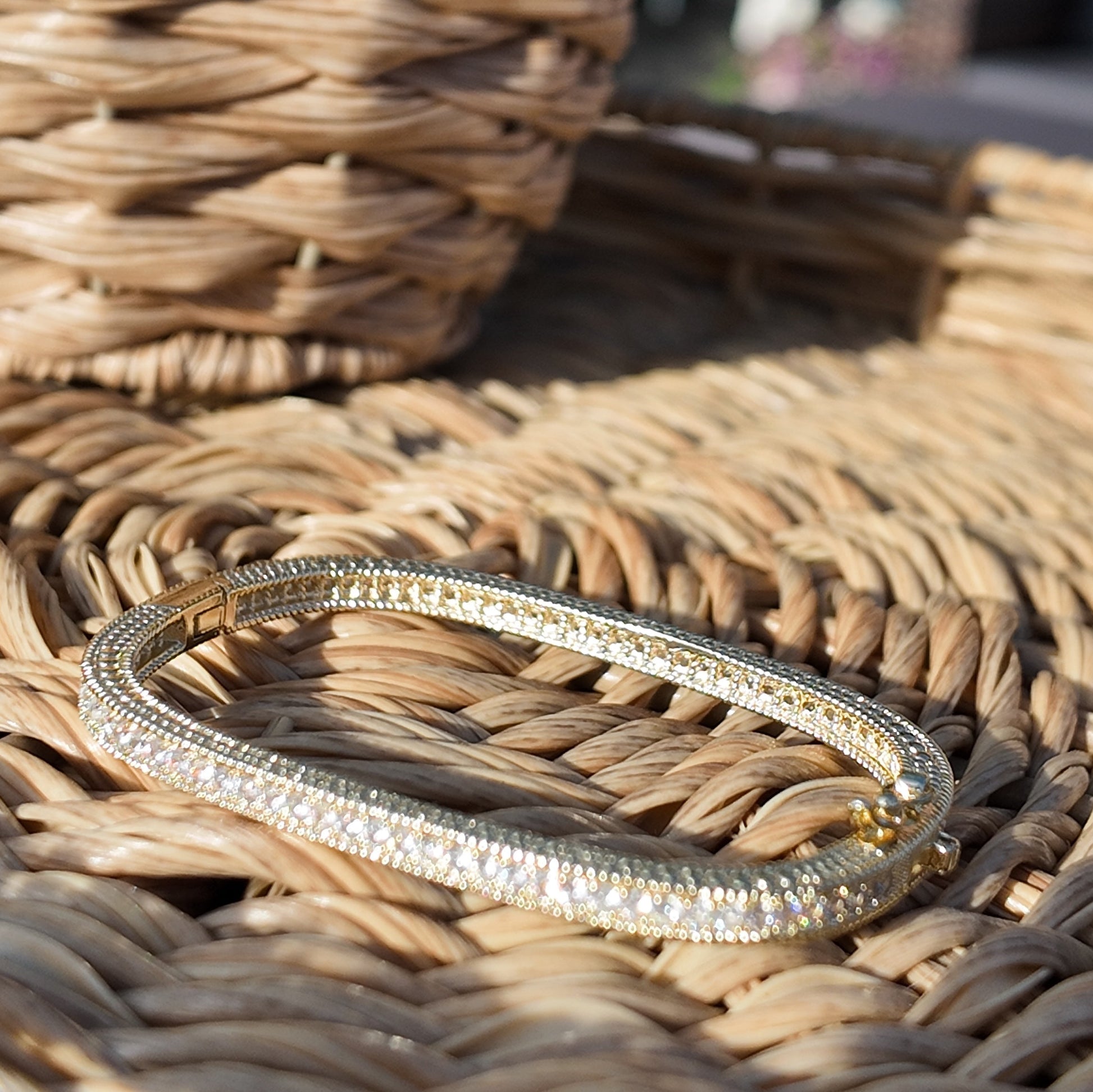     Monaco pavé tennis bracelet styled on woven rattan surface in natural light