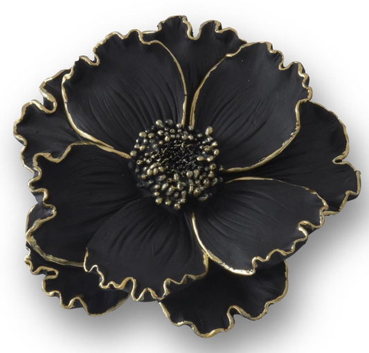 Black flower-shaped object with gold accents on a white background