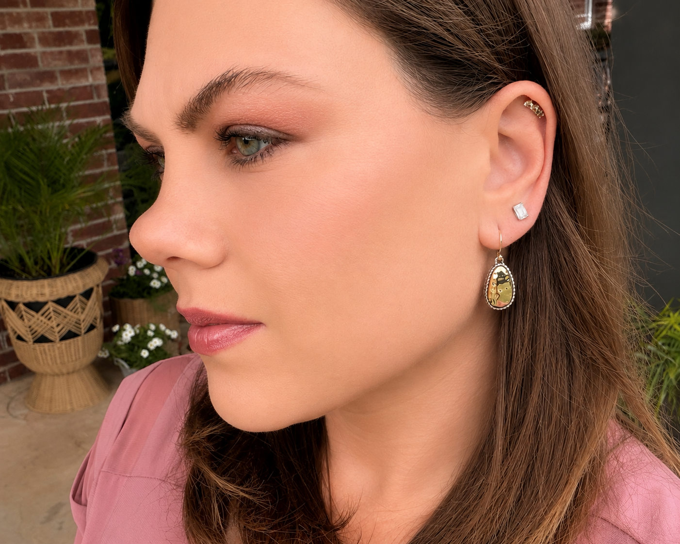 Side profile of mixed metal teardrop earrings styled outdoors